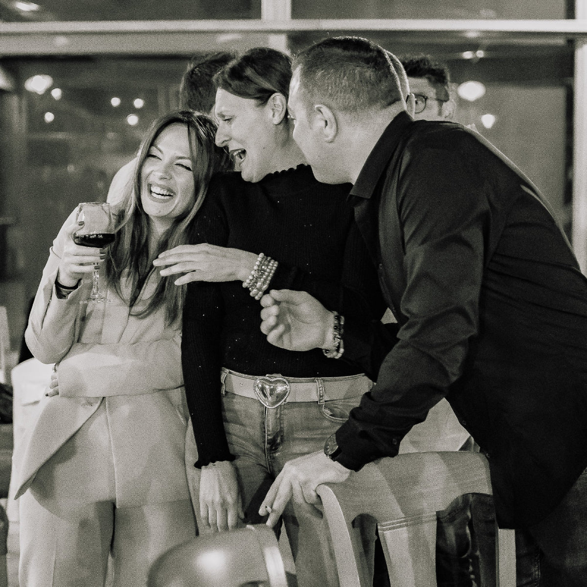 persone ridono con vino in mano